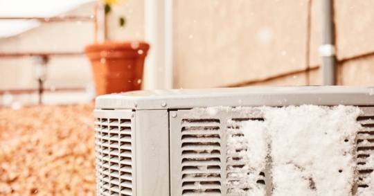heat pump outdoor unit with visible frost or light ice