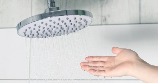 Female hand checking water temperature
