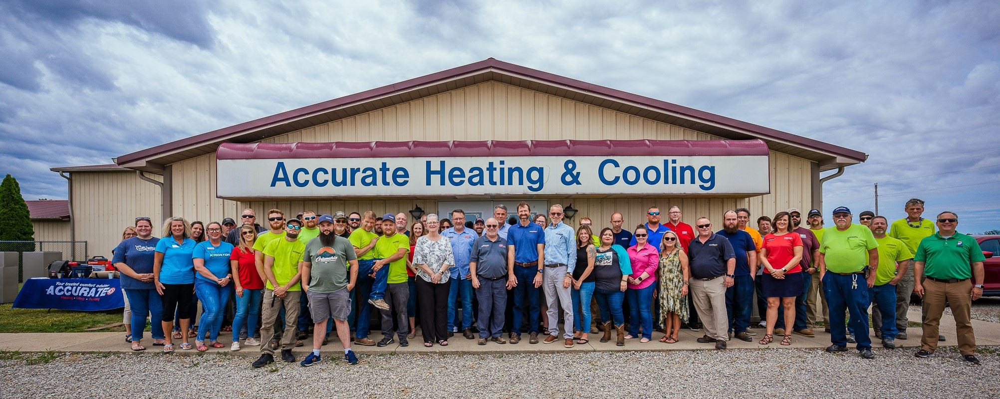 Accurate Team Standing In Front of Building With Business Signage